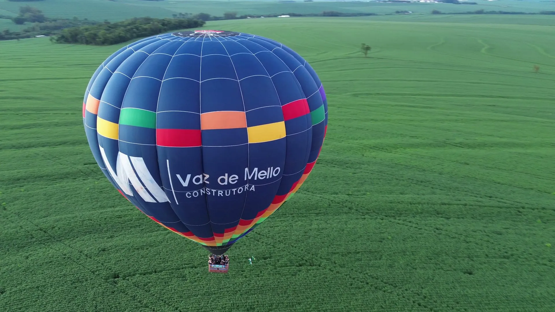 Balão com a marca Vaz de Mello Construtora sobre as lavouras