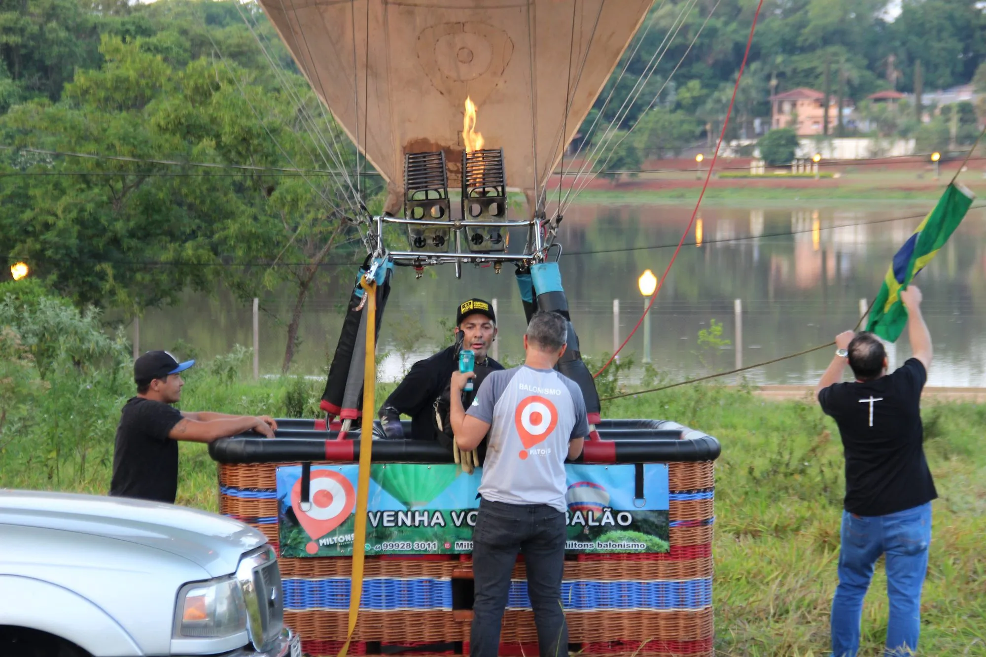 Equipe preparando o cesto do balão ao lado de um lago